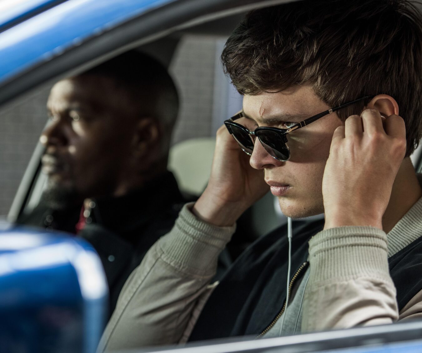 Baby (ANSEL ELGORT) and Bats (JAMIE FOXX) on the way to the post office job with Buddy (JON HAMM) and Darling (EIZA GONZALEZ) as cops pull up next to them in TriStar Pictures' BABY DRIVER.