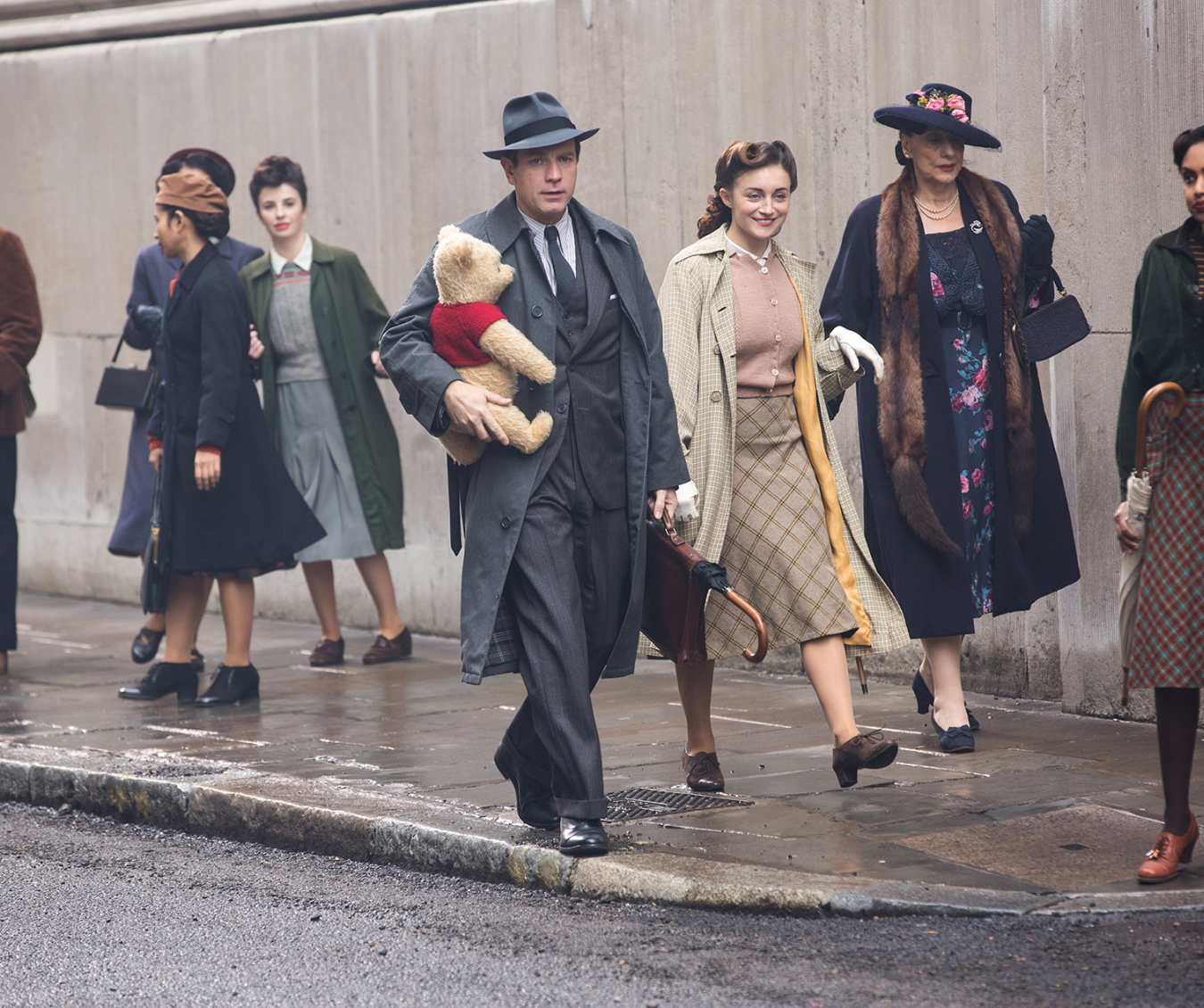 Christopher Robin (Ewan McGregor) and his longtime friend Winnie the Pooh walk down the street in London in Disney’s CHRISTOPHER ROBIN.